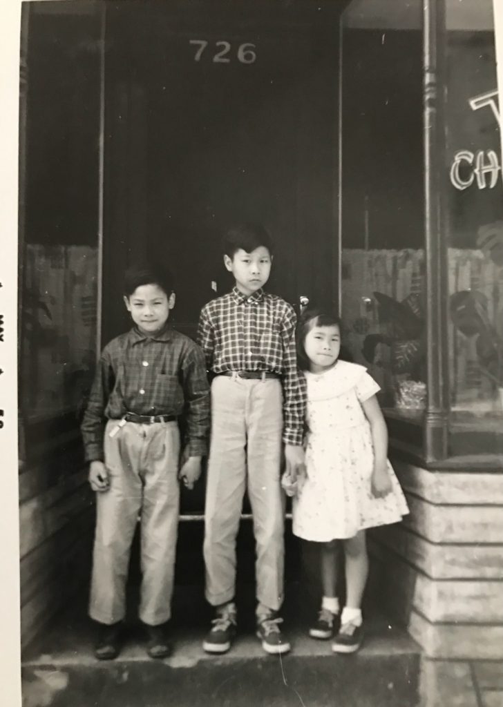 ThreeTom family children stand in front door of family restaurant.